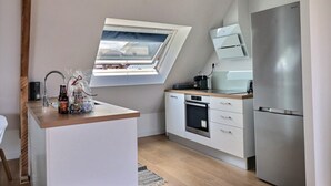 Una cucina moderna con finestra a lucernario, forno integrato e frigorifero in acciaio inossidabile.