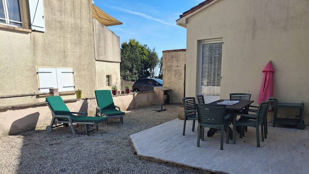 A patio with outdoor furniture, a table, and a covered area. - Single-storey house type III, 80 m from the sea and 10 mins from the town center (Préfailles)