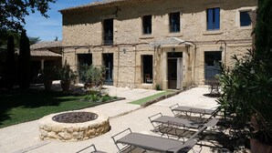 A stone building with a courtyard, outdoor seating, and a fire pit.
