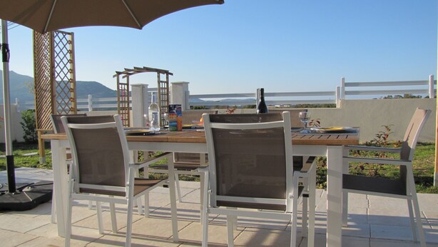An outdoor dining area with a table and chairs, a pergola, and a view of the ocean. - PROVENCAL STYLE HOUSE WITH SEA VIEW (Calenzana)