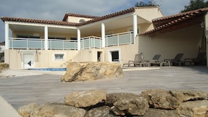 A two-story building with a swimming pool, outdoor seating, and a rocky foreground. - A haven of peace nestled in the heart of Provence (Istre)