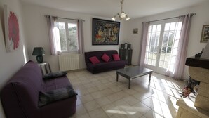 Una sala de estar con un sofá morado, una mesita de centro y un cuadro en la pared.