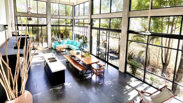 A spacious indoor area with a large window, a sofa, a dining table, and a bench. - Villa/Boutique 4 BDR VIP Concierge/Chef in la Veleta Tulum (La Veleta Tulum)