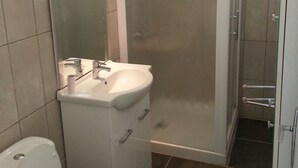 Ein Badezimmer mit Toilette, Waschbecken und Dusche.