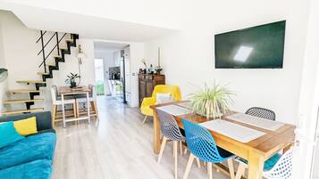 Un espace de vie moderne comprenant un coin repas, un escalier et une cuisine.