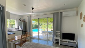 A bedroom with a bed, a TV, a dining area, and a view of the outdoors. - New cottage, with swimming pool facing the Luberon (Robion)