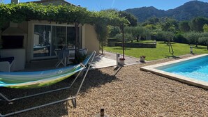 A pool area with a clear sky, a hammock, and a building with a pergola. - New cottage, with swimming pool facing the Luberon (Robion)