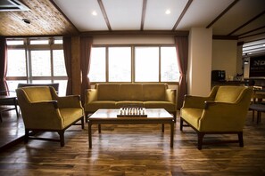 A living room with a sofa set, two armchairs, a coffee table, and a chessboard. - Nomad Hakuba (Hakuba)