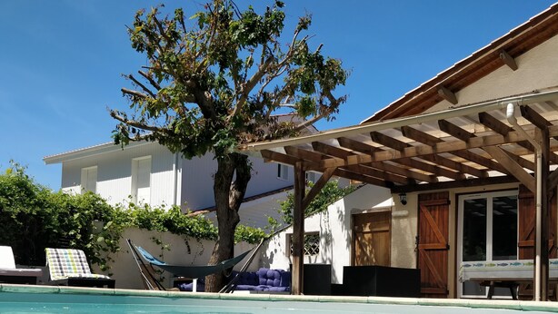 A clear swimming pool with a wooden pergola and a hammock. - Family villa ideally located on the Basin with heated pool (La Teste-de-Buch)