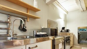 A modern kitchen with stainless steel appliances, wooden cabinets, and a built-in oven.
