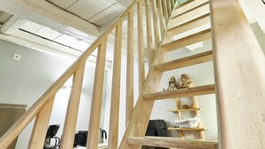 A wooden staircase with a view of a kitchen area below.