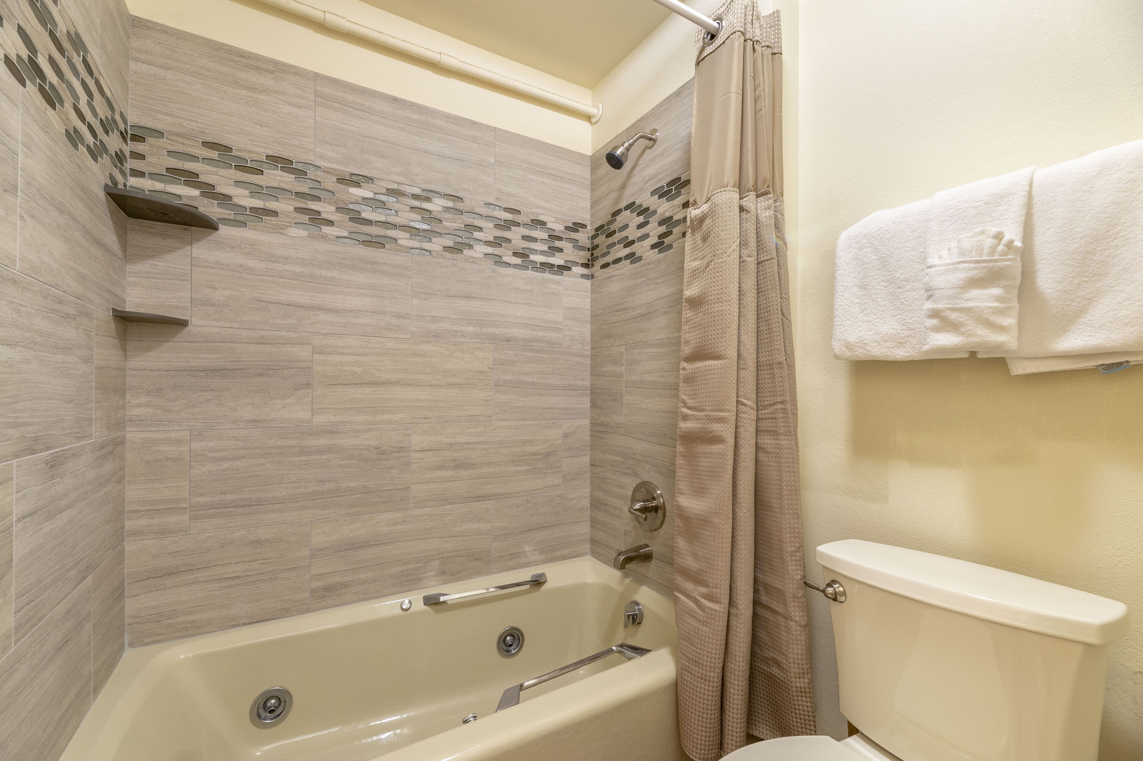 A bathroom with a bathtub, shower, and toilet.