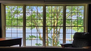 A room with a large window overlooking a lake, a wooden desk, and a chair. - Main house & guest cottage on over 400 feet of waterfront on the public side (Mineral)