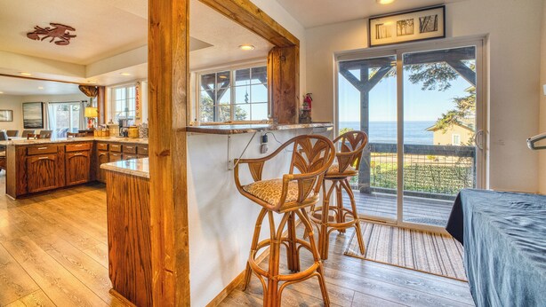 A spacious kitchen with wooden cabinets, a large island, and a view to the outside.