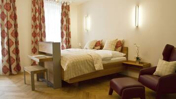 Ein Schlafzimmer mit einem Bett, Nachttischen, einem Schreibtisch, einem Stuhl und einer Bank.
