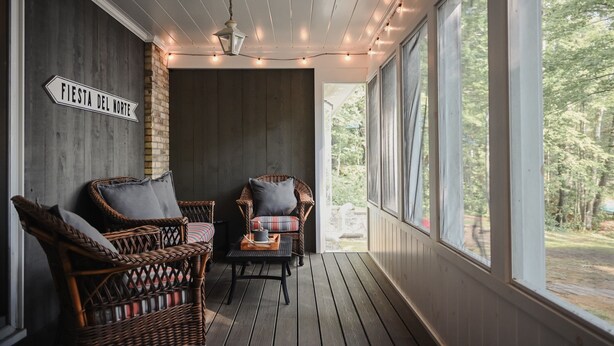 A cozy porch with wicker furniture, a sign reading "Fiesta del Norte", and a view of the outdoors.