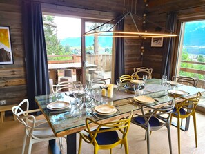 A dining area with a glass table, chairs, and a view of the outdoors.