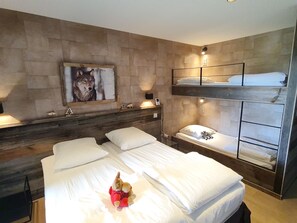 A hotel room with a bunk bed, a painting of a wolf, and a stuffed toy on the bed.