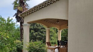 A covered outdoor seating area with a pergola, a palm tree, and a patio table and chairs. - BEAUTIFUL RECENT PROPERTY WITH ALL COMFORT, 5 MINS FROM VANS (Pigère)