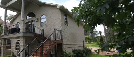 A two-story house with a covered porch, a staircase, and a well-maintained lawn.