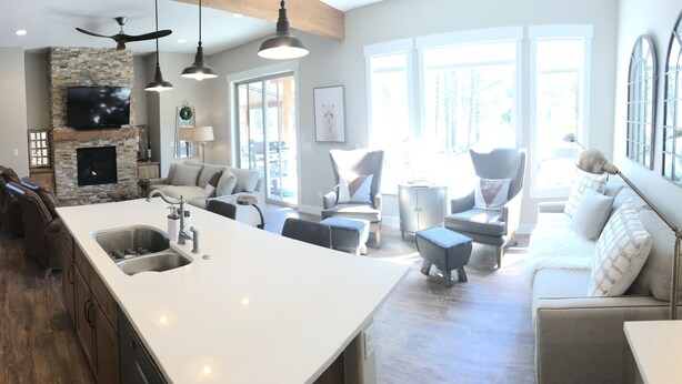 A spacious living area with a large island, a fireplace, and a view of the outdoors. - Look No Further! Brand New Build in Winter Park/Fraser (Fraser)