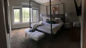 A four-poster canopy bed with a fluffy white bench, a tripod lamp, and a framed picture on the wall. - Look No Further! Brand New Build in Winter Park/Fraser (Fraser)