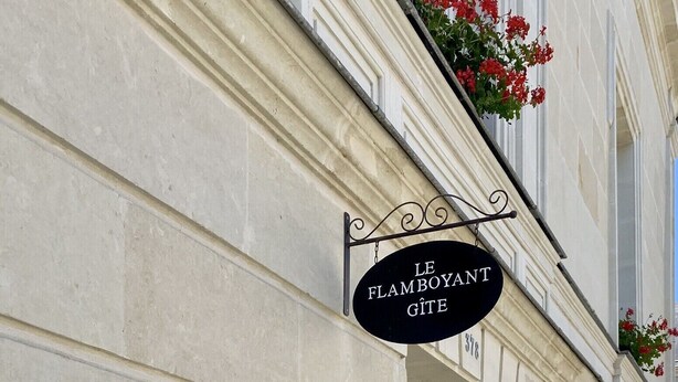 Fachada de edificio con un letrero que dice 'Le Flamboyant Gîte 378'.