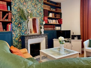 Un soggiorno con camino, librerie, televisore e tavolino da caffè.