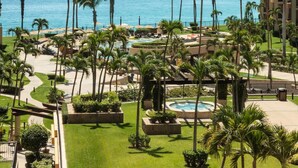 A resort with a pool, palm trees, and a view of the ocean. - Beachfront Paradise! Central ocean view and full resort amenity access! (Cabo San Lucas)