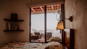 Een kamer met een bed, een boekenkast, een raam met uitzicht en een lamp.