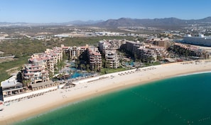 Une station balnéaire comprenant plusieurs bâtiments d’hôtel, une plage et un espace piscine.