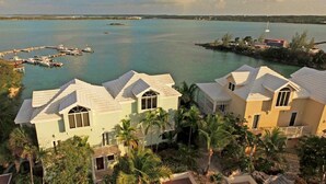A coastal property with multiple buildings, a marina with boats, and a clear view of the sea. - 3 Bedroom 3.5 Bath Villa on the Water (Exuma)
