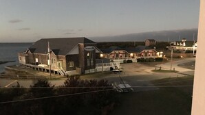 Un hotel frente al mar con varias construcciones y vista a la playa, con un letrero que dice 'Ocean Air'.