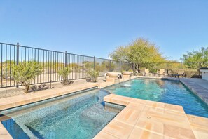 A pool area with two swimming pools, a fence, and outdoor seating.