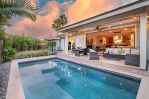 Relax by the pool surrounded by lush greenery and comfortable lounge chairs.