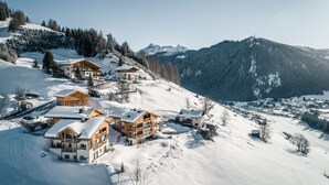 A snow-covered mountain village with wooden chalets and a ski resort. - Lüch de Costa (Corvara in Badia)