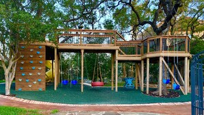 Une aire de jeux avec des structures d’escalade, des balançoires et un toboggan.