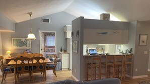Un espai habitable compacte amb zona de menjador, petita cuina i saló amb sofà.