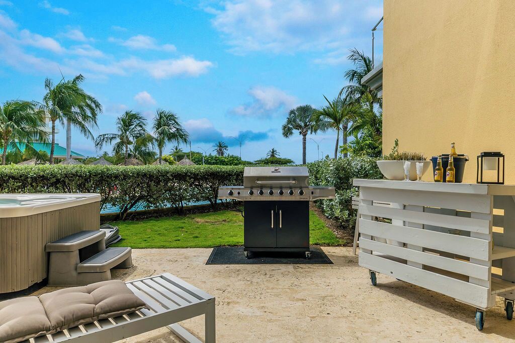 Une terrasse extérieure équipée d’un barbecue, d’un jacuzzi et d’un espace détente.