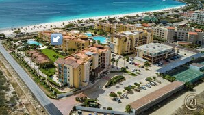A resort with multiple buildings, a swimming pool, and a beach.