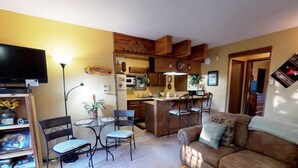 A compact living space with a kitchen, dining area, and a sofa.