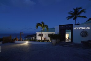 Un edificio moderno con un letrero que dice "MYSTIQUE" al caer la noche.
