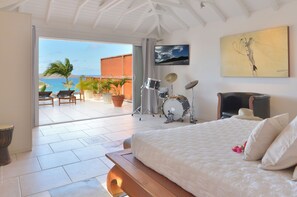 Un dormitorio con una cama, un set de batería y vistas al océano.