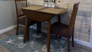 A dining area with a wooden wall, a compass decoration, and a table with chairs.