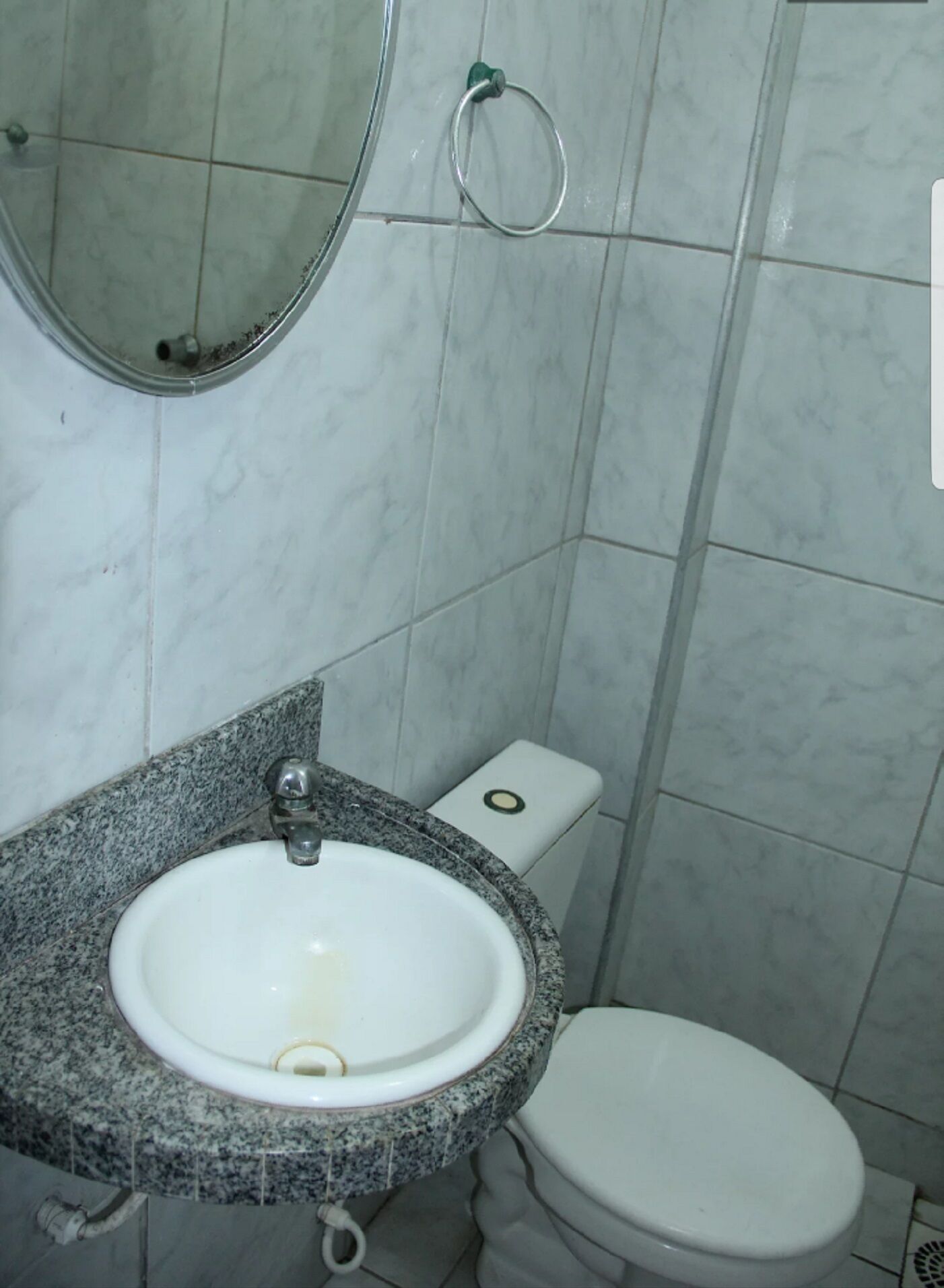 Une salle de bain avec un lavabo en granit, des toilettes et un miroir.