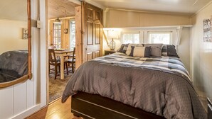 Une chambre à coucher avec un grand lit, une tête de lit en bois, un bureau et une chaise.