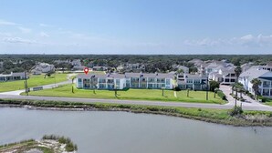 Un barrio residencial con casas modernas, un lago pequeño y un cielo despejado.