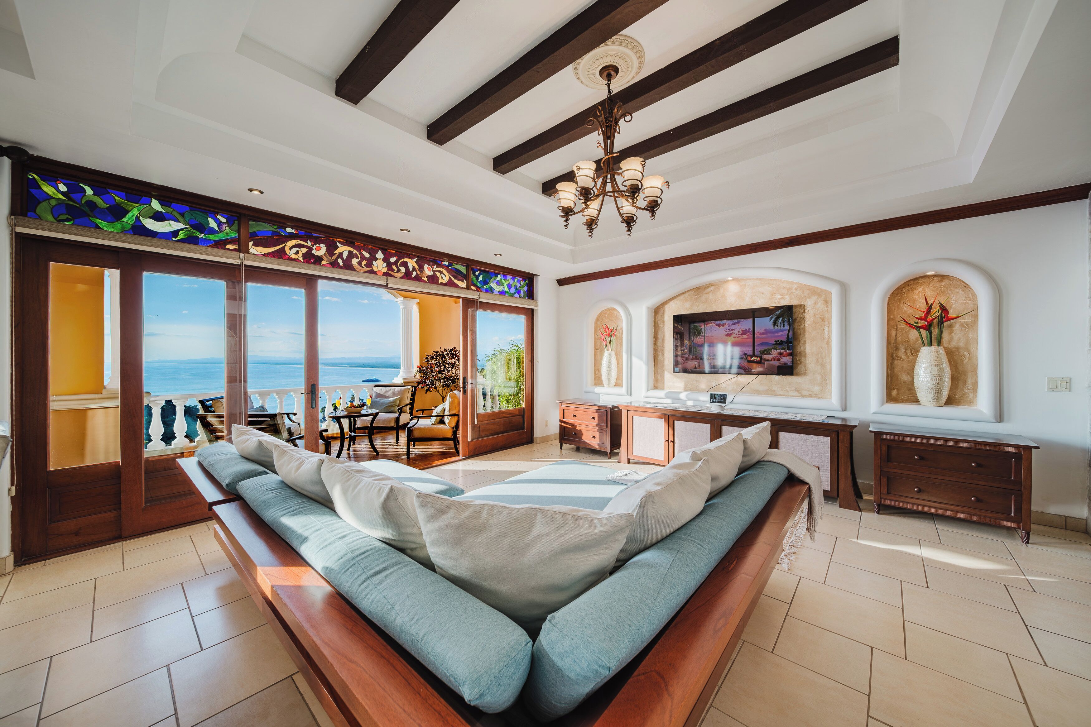 Una habitación amplia con una cama grande, zona de comedor y vistas al mar.