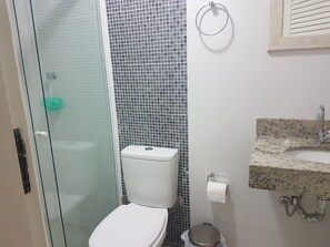 Chuveiro, secador de cabelo, toalhas de banho, papel higiênico
