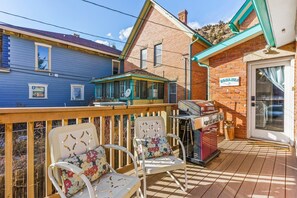 A patio with two white chairs, a barbecue grill, and a sign reading "BONAMZA".